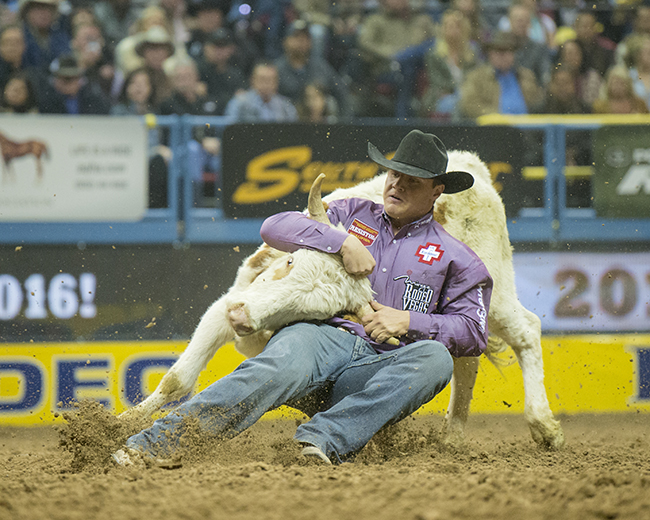 J.D. Struxness wrestles his steer to the ground in 3.9 seconds to share the third-round victory Saturday at the Wrangler National Finals Rodeo. (RIC ANDERSEN PHOTO)