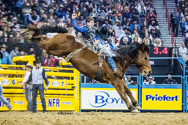 Tanner Aus rides Three Hill Rodeo's Jr. Bonner for 87 points Wednesday to win the seventh round at the Wrangler National Finals Rodeo. It was his second round title in seven days. (TODD BREWER PHOTO)
